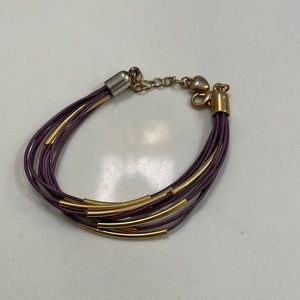 Adjustable purple and gold bracelet. Gold metal on top moves.